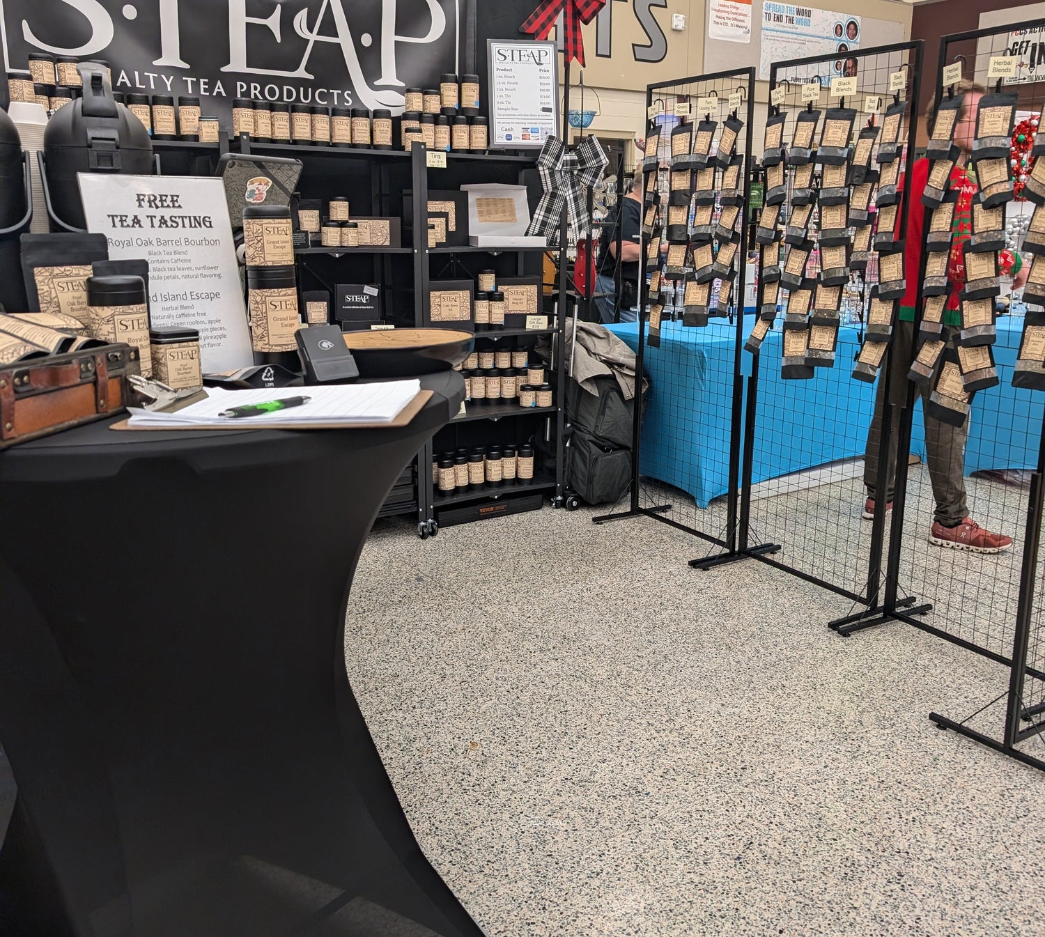 Tea store interior with shelves displaying tea products and a black table.